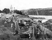 Летняя деревня Пазрецких саамов-колтта на левом берегу р. Паз. На заднем плане — новая Борисоглебская церковь. 1874 г. Фото W. J. O. Grant. Из фондов Печенгского краеведческого музея 